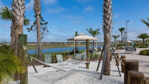 A beach with a hammock, a gazebo, and palm trees. - Last Minute Disney! Private Pool, Hot Tub & Themed Bedrooms. Book Now! #93745 (Orlando)