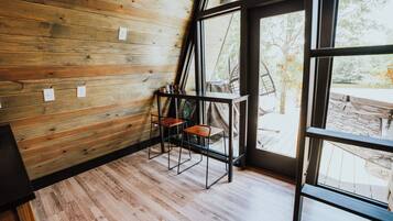 Una habitación con paneles de madera, piso de madera y ventanas grandes que dan al exterior.