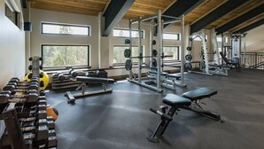 A gym with weightlifting equipment, benches, and a squat rack.