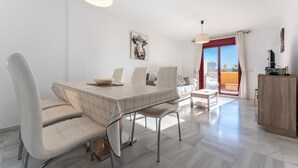 Un comedor moderno con mesa, sillas e iluminación colgante.