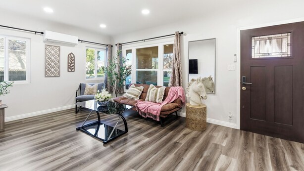 Una sala de estar moderna con un sofá, una mesa de centro y un espejo decorativo.