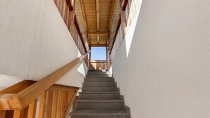 A staircase with wooden handrails and a view of the sky through the top.