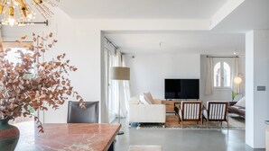 Un salon moderne avec une table en marbre, un canapé et un téléviseur.