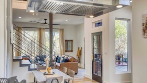 Ein modernes Wohnzimmer mit Treppe, Essbereich und Blick ins Freie.