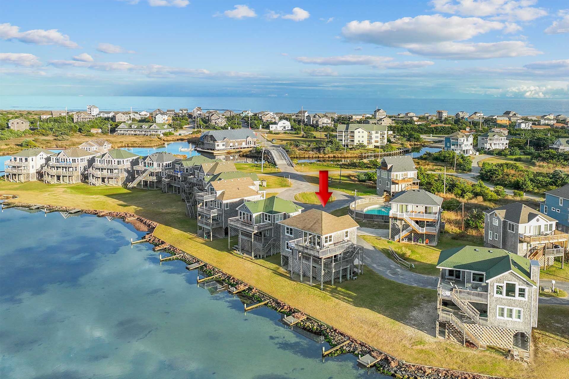 A coastal residential area with waterfront properties, including houses with decks and a swimming pool.