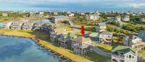 A coastal residential area with waterfront properties, including houses with decks and a swimming pool.