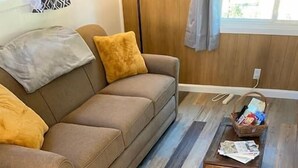 Un salon avec un canapé marron, une table basse en bois et un sol à motifs.