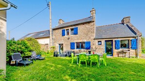 A stone house with a garden, outdoor seating, and a chimney. - Holiday Home 'Maison 6 Personnes Avec Piscine' with Private Pool and Wi-Fi (Le conquet)