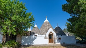 Il s’agit d’un bâtiment traditionnel doté d’une façade en pierre, d’une porte en bois et d’un petit jardin.