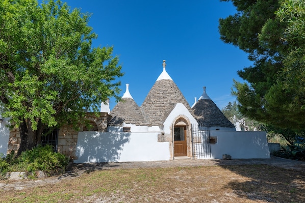 A traditional building with a stone facade, a wooden door, and a small garden area.