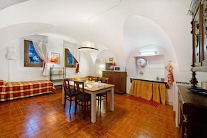 Un espacio habitable compacto con comedor, kitchenette y cama.