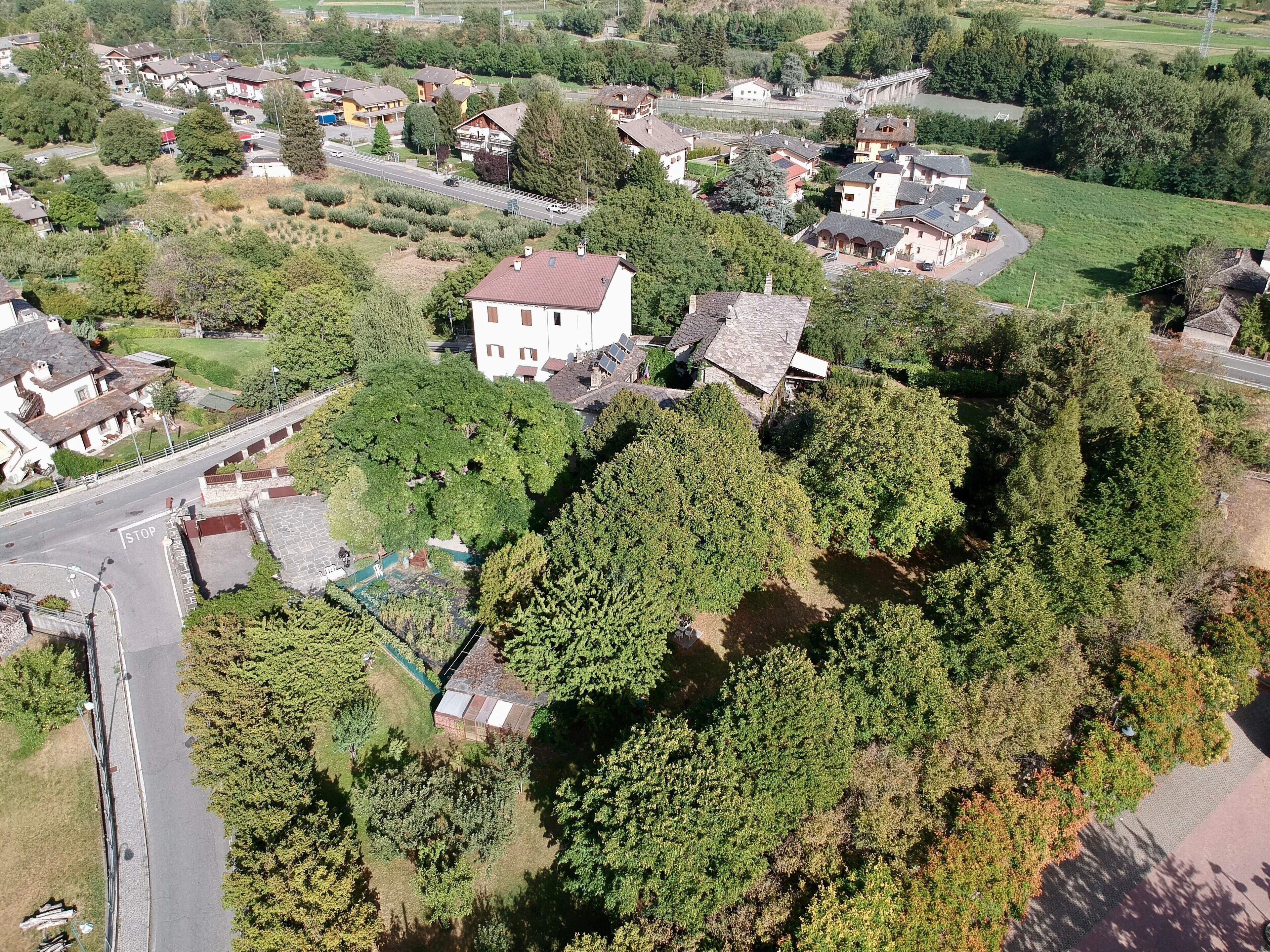 An aerial view of a residential area with houses, a road, and a bridge.