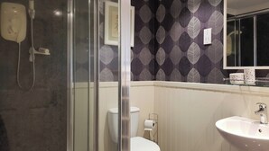 A bathroom with a glass shower enclosure, a toilet, and a sink. - Leven Lodge 3 - UK46045 (Loch Lomond)