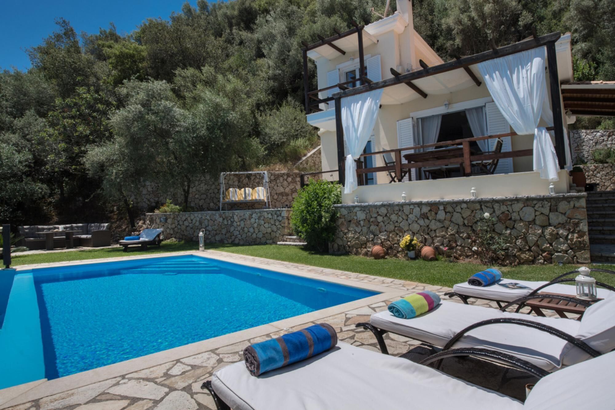 Una piscina amb gandules i una paret de pedra.