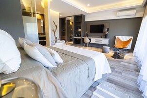 Un dormitorio moderno con una cama grande, un escritorio y un televisor.