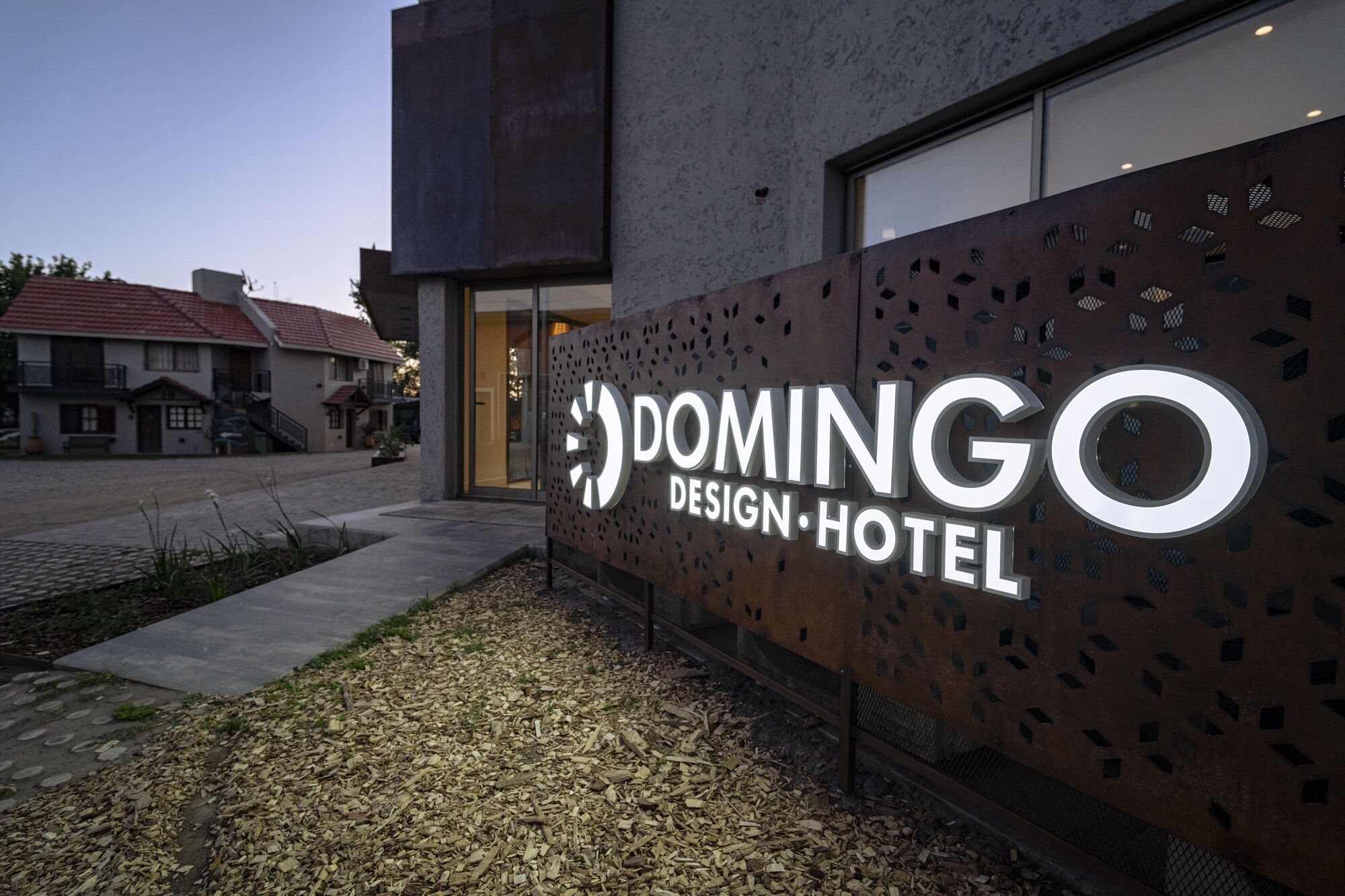 A modern building with a sign for 'Domingo Design Hotel'.