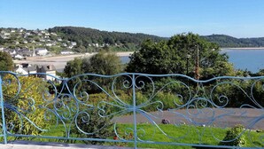 Ein malerischer Blick auf eine Küstenstadt, im Vordergrund ein Metallzaun.