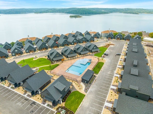 A residential area with multiple houses, a swimming pool, and a parking lot.