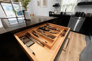 A kitchen with a built-in drawer organizer containing various kitchen utensils.
