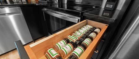 Un cajón de cocina con varios frascos de especias.