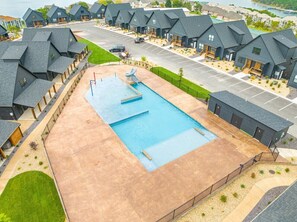 A residential area with multiple houses, a swimming pool, and a parking lot.