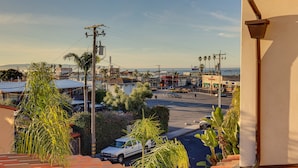 A residential area with a street view, including houses, parked cars, and palm trees. - Walk to Town & Ocean! Pismo Beach Condo (Pismo Beach)
