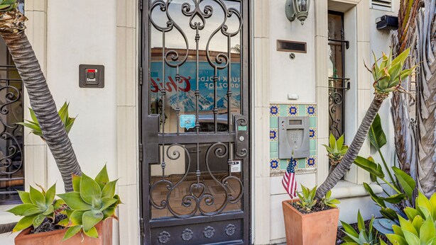 A building entrance with a wrought iron gate, potted plants, and a mailbox. - Walk to Town & Ocean! Pismo Beach Condo (Pismo Beach)