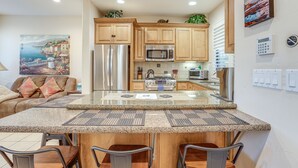 A modern kitchen with granite countertops, stainless steel appliances, and wooden cabinets. - Walk to Town & Ocean! Pismo Beach Condo (Pismo Beach)