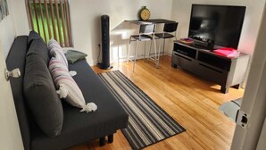 A modern living room with a sofa, TV, and a small table with chairs. - Private Apartment Miami Kendall near Zoo, The Falls Mall, and Miami Dade College (Miami)