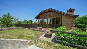 Un bâtiment rustique en bois, doté de grandes fenêtres et d’une façade en briques.
