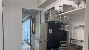 A modern kitchen with a refrigerator, microwave, and sink. There is a patterned rug and a ceiling light fixture. - West Hollywood, Hollywood Hills, Sunset Strip House with Beautiful Views (Beverly Hills)
