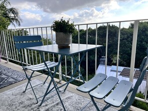 A balcony with a table, chairs, a potted plant, and a view of the city. - West Hollywood, Hollywood Hills, Sunset Strip House with Beautiful Views (Beverly Hills)