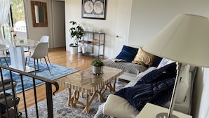 A modern living room with a sofa, a coffee table, a TV stand, and a dining area with chairs and a table. - West Hollywood, Hollywood Hills, Sunset Strip House with Beautiful Views (Beverly Hills)