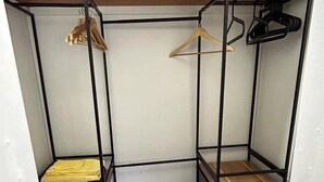 A compact room with a bunk bed, a wooden shelf, a desk with drawers, and a hanging rack. - B’s Hidden Paradise (Mary’s Fancy)