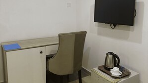 Un pequeño espacio de oficina con escritorio, silla y refrigerador.