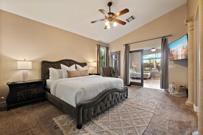 A bedroom with a large bed, a ceiling fan, and a view of the outdoors through a sliding door. - PRIVATE GILBERT RETREAT - Pool, Hot Tub, Sauna & Games (Gilbert)