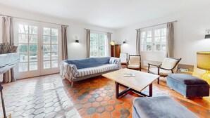 A spacious living area with a sofa, chairs, a coffee table, and a lamp.
