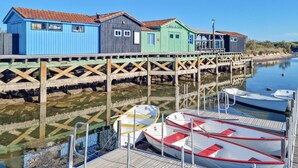 A pier with colorful wooden buildings and boats docked at the end.