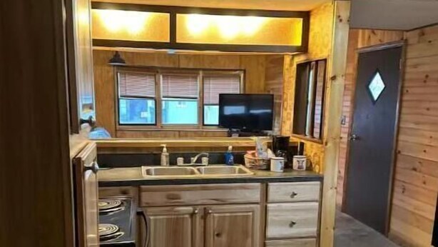 Una cocina compacta con armarios de madera, una estufa integrada y una pequeña encimera.