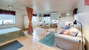 A cozy living room with a sofa, a small table, a TV, and a dining area with chairs and a table. - 1 bedroom awesome home in Ljungbyhed (Ljungbyhed)