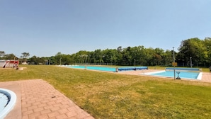 A swimming pool area with multiple pools, a covered seating area, and a small building. - 1 bedroom awesome home in Ljungbyhed (Ljungbyhed)