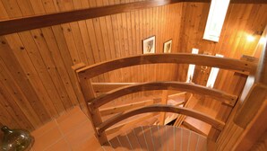 A wooden spiral staircase in a cabin with wooden walls and a tiled floor. - 3 bedroom lovely home in San Giorgio (San Giorgio)