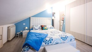 A bedroom with a bed, a bedside table, a lamp, and a radiator. - Comfortable attic located on the third and last floor of a building without a lift.It comfortably accommodates two people in 40 m2 of space with a double bedroom.Small building with a green space and ample free parking in front of the house, near the cen (Parma)