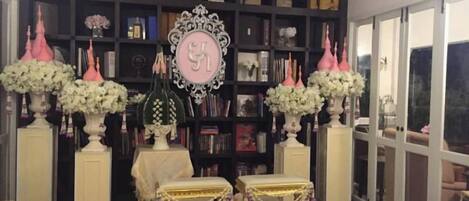 A room with a bookshelf, decorative vases, and a chandelier.