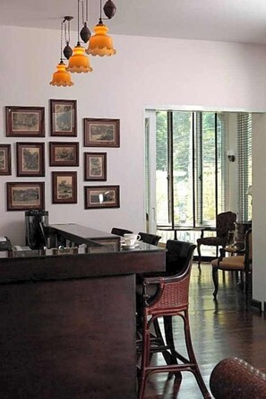 Una habitación con comedor, mostrador de cocina y una pared decorada con cuadros.
