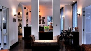 A modern interior with a central column, seating area, and a dining table with chairs. - Ping Nakara Boutique Hotel and Spa (Chiang Mai)