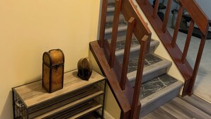 Una escalera con barandas de madera y un reloj en la pared.