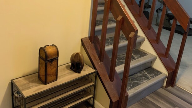 A staircase with wooden railings and a clock on the wall. - 2-bedroom house in welcoming Lawrenceville with WiFi, fitness room, AC (Lawrenceville)