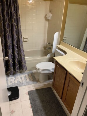 A bathroom with a bathtub, toilet, and sink.