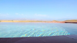 A clear pool with a view of distant hills and a clear sky. - Revolution Stone Cliff Eco Resort  (Agafay)